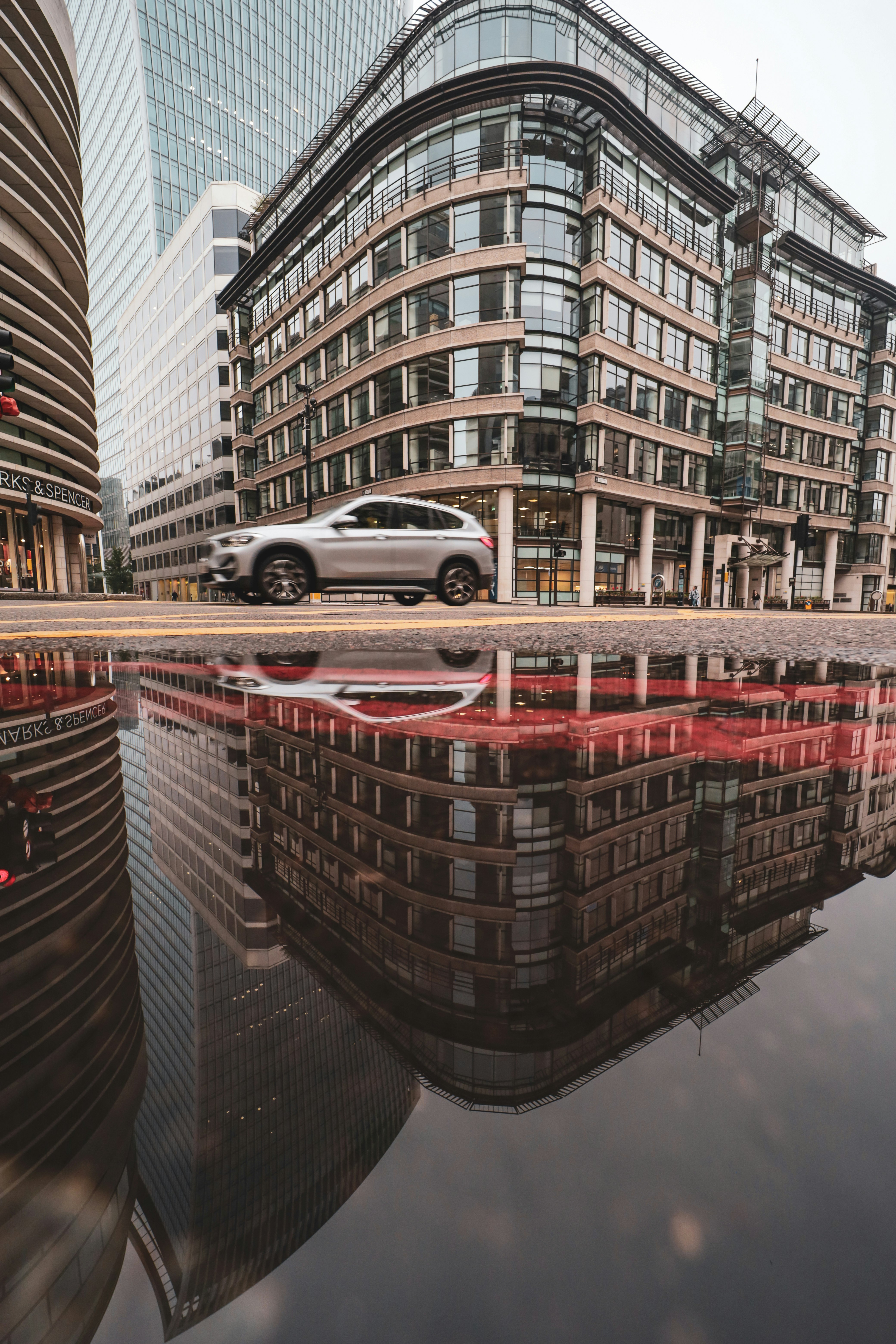 white sedan on road near high rise buildings during daytime